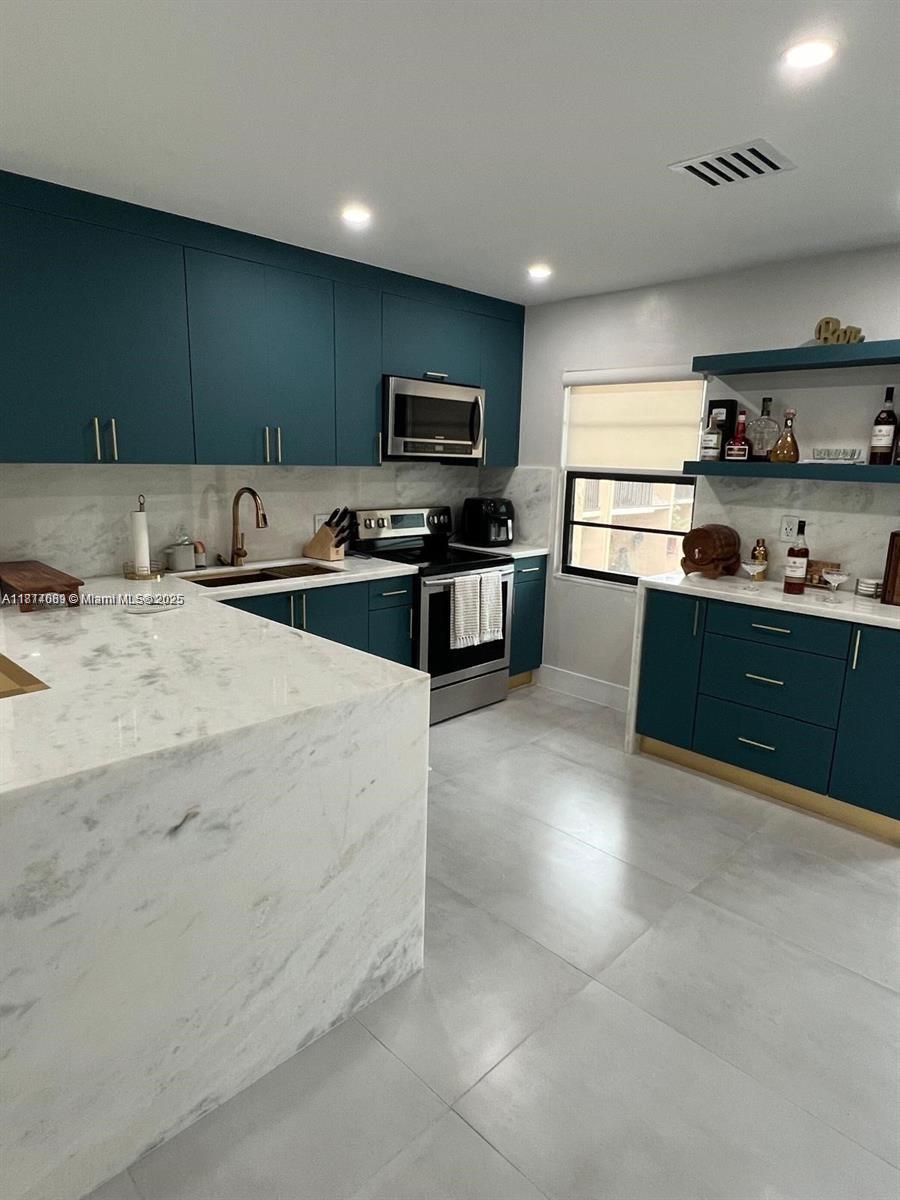 1103 South Collier Boulevard, Unit C108 Marco Island, FL 34145 - Photo 5 of 34 a kitchen with stainless steel appliances kitchen island granite countertop a sink and cabinets