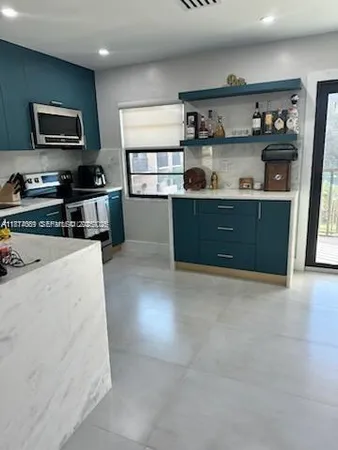 a kitchen with stainless steel appliances cabinets and wooden floor