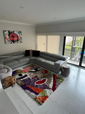 a living room with furniture and a floor to ceiling window