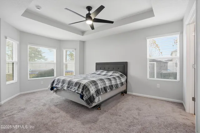 a spacious bedroom with a bed painting and a large window