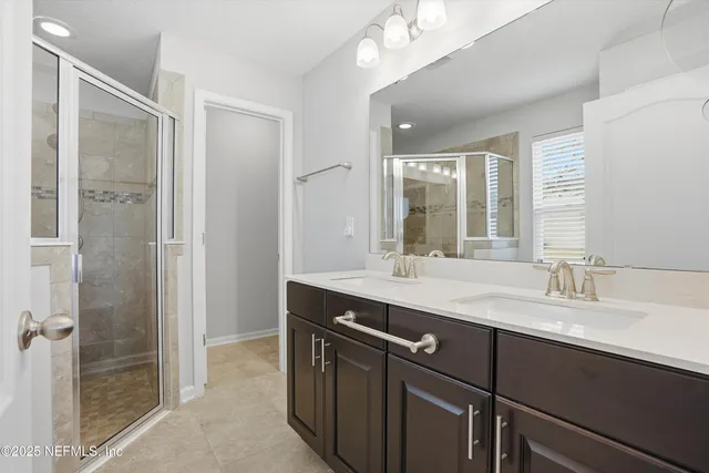 a bathroom with a double vanity sink mirror and shower
