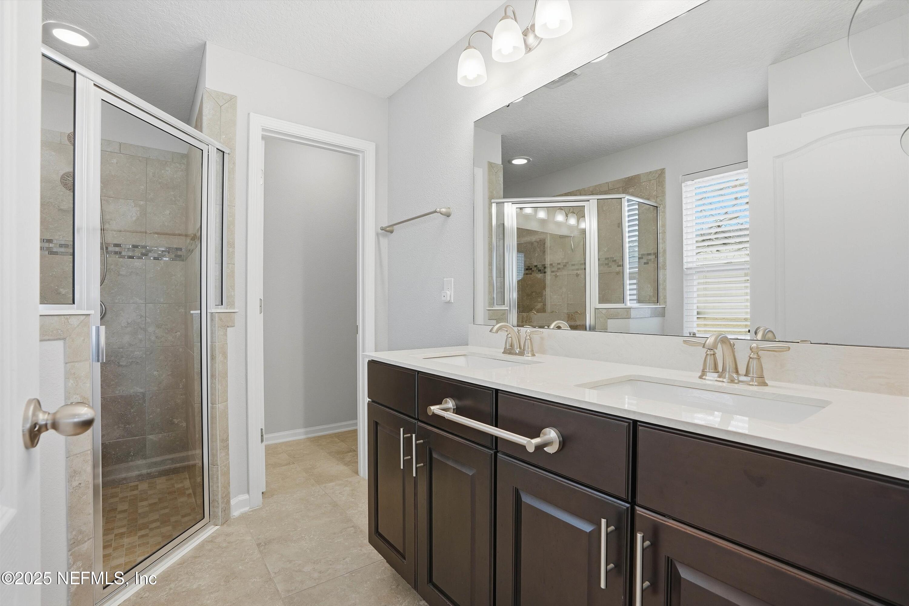 3994 Great Falls Loop Middleburg, FL 32068 - Photo 16 of 30 a bathroom with a double vanity sink mirror and shower