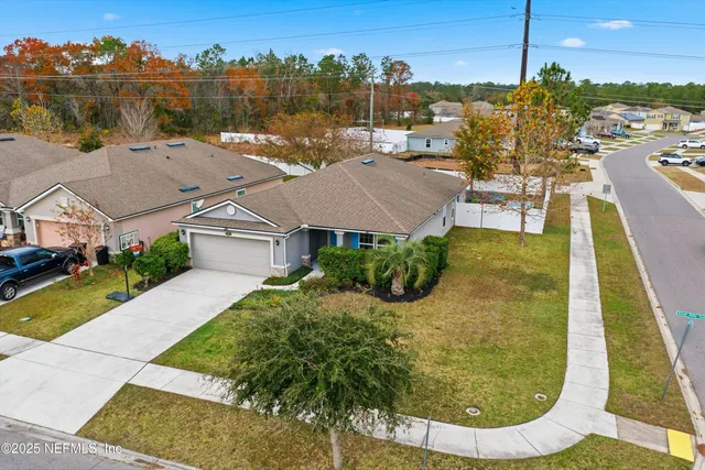 an aerial view of residential houses with outdoor space and trees
