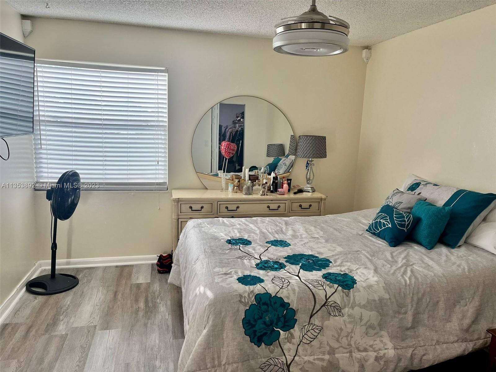 500 Davis Road, Unit 30 Palm Springs, FL 33461 - Photo 9 of 15 a bedroom with a bed and a chandelier