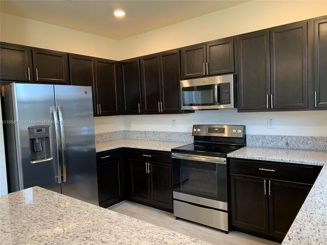 a kitchen with wooden cabinets and stainless steel appliances