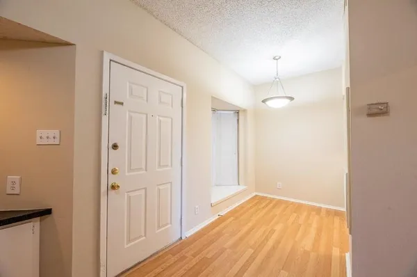 a view of a room with wooden floor and a ceiling fan