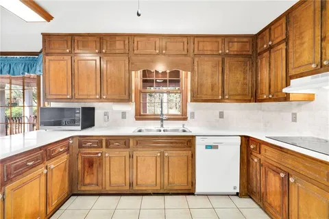 a kitchen with stainless steel appliances granite countertop a refrigerator a stove and a sink