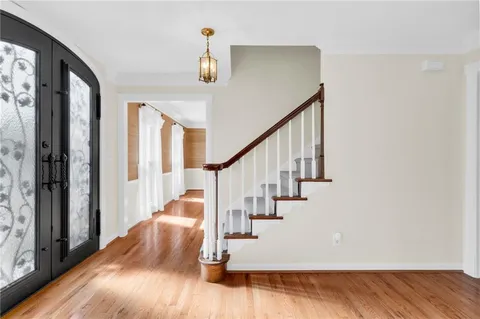 a view of entryway and hall with wooden floor