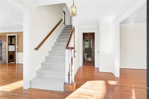 a view of a livingroom with wooden floor a ceiling fan and window