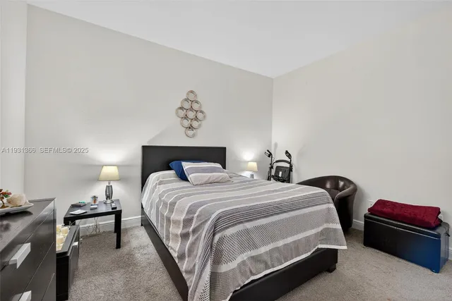 a bedroom with a bed and a lamp on dresser