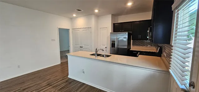 a kitchen with a refrigerator sink and wooden cabinets
