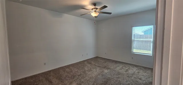 an empty room with closet and a chandelier fan