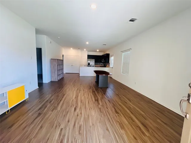 a view of kitchen with stainless steel appliances wooden floor and a sink