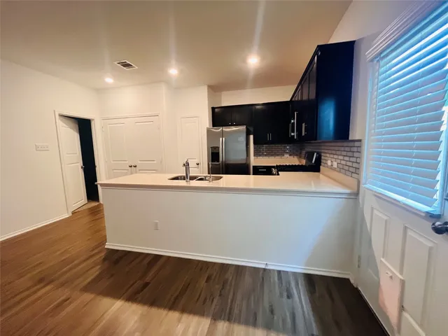 a kitchen with refrigerator cabinets and wooden floor