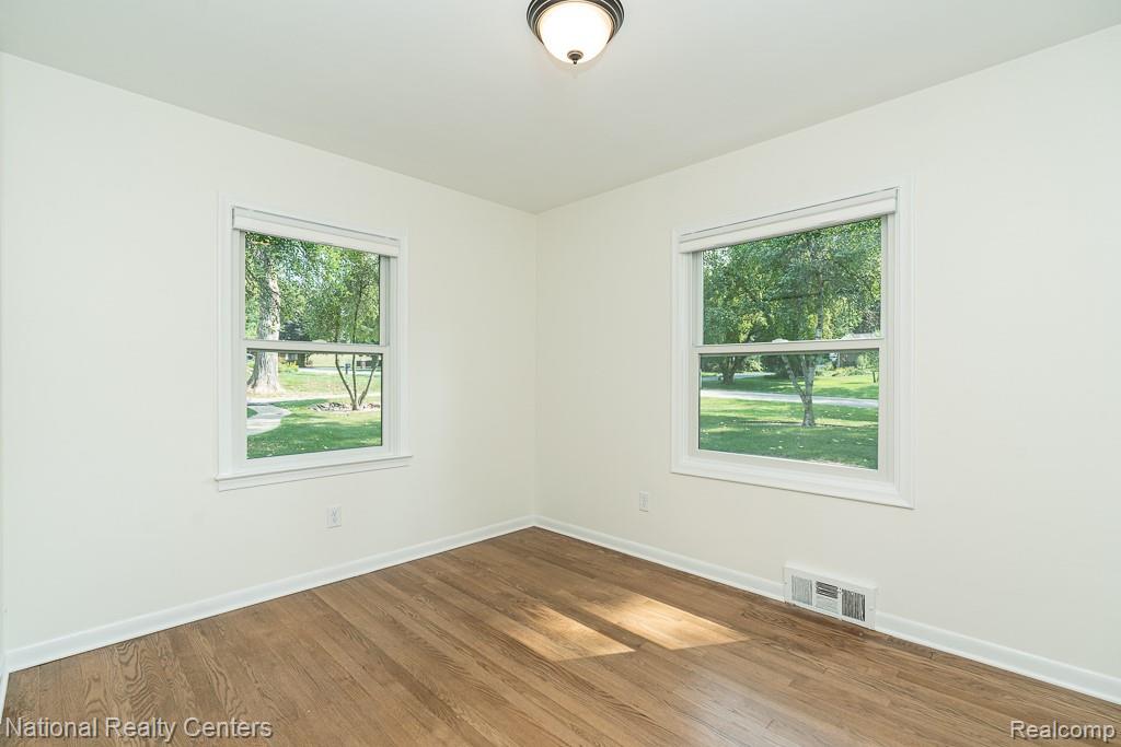 144 West Maryknoll Road Rochester, MI 48309 - Photo 32 of 38 Hardwood flooring, white painted walls, and twin double-hung windows with white trim