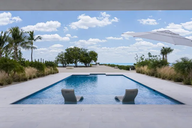 a kitchen with stainless steel appliances granite countertop wooden cabinets a dining table and chairs