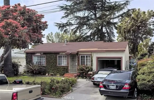 a front view of a house with a garden and plants
