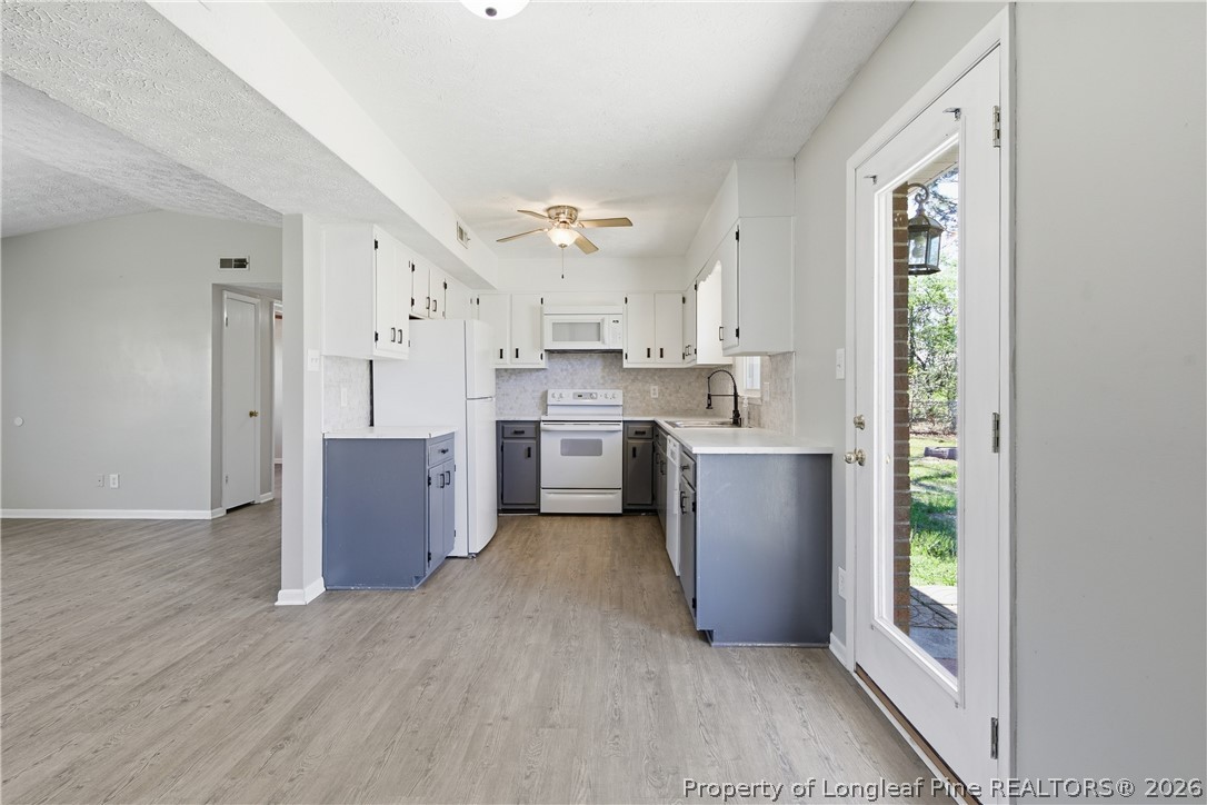 6319 Rustic Ridge Hope Mills, NC 28348 - Photo 18 of 39 a kitchen with kitchen island white cabinets and stainless steel appliances