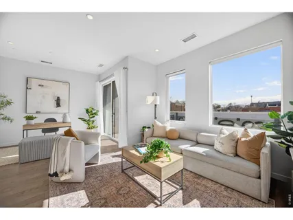 a living room with furniture a dining table and a potted plant