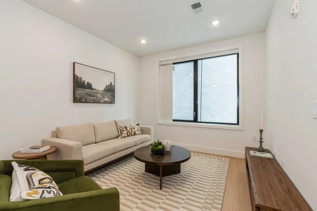 a kitchen with stainless steel appliances a dining table chairs and refrigerator