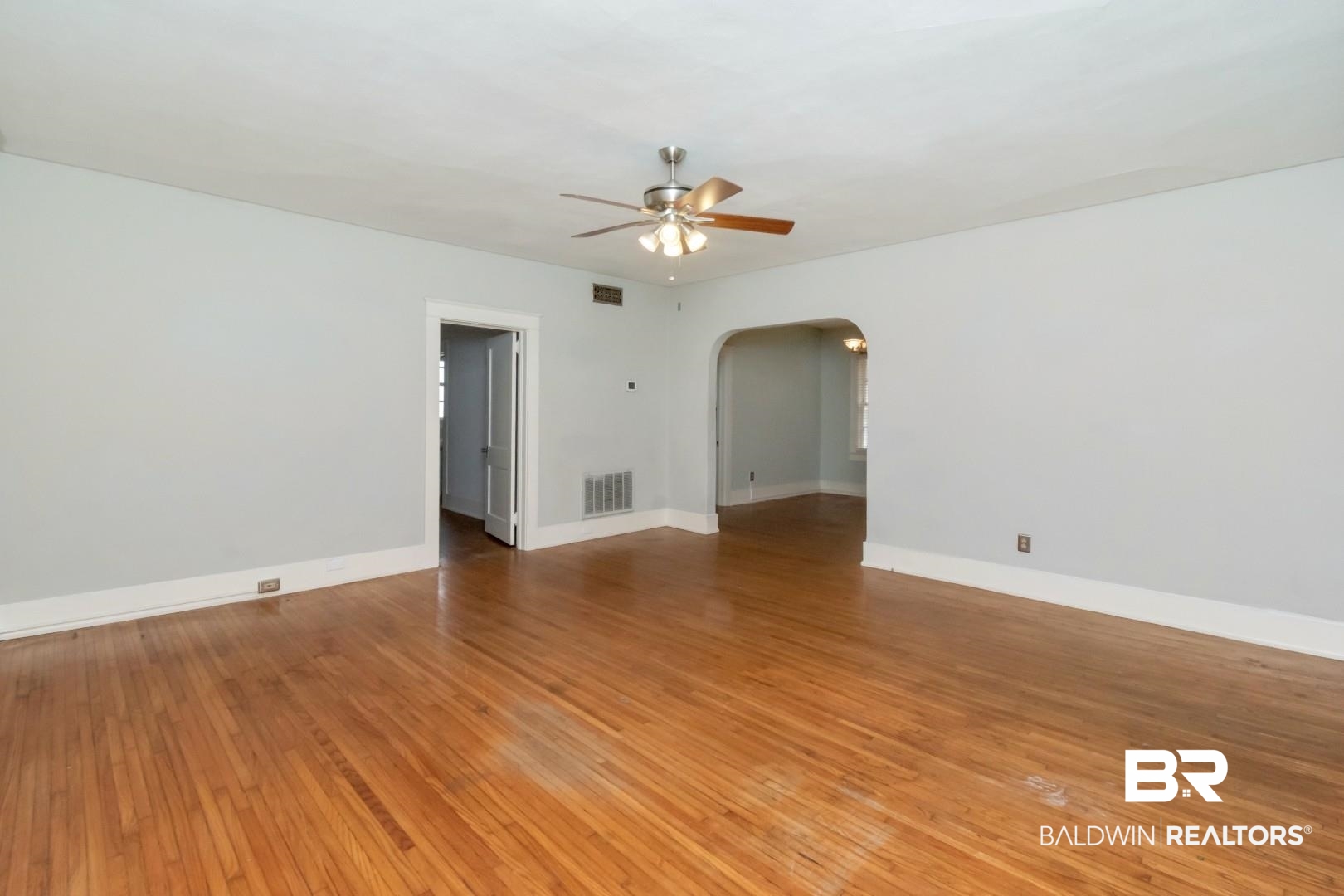 1602 Government Street, Unit 1A Mobile, AL 36604 - Photo 6 of 24 Empty room with a ceiling fan, light wood-style floors, and arched walkways