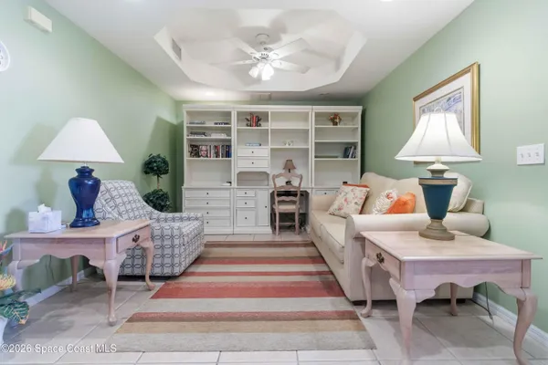 a spacious bedroom with a bed next to a window and a chandelier