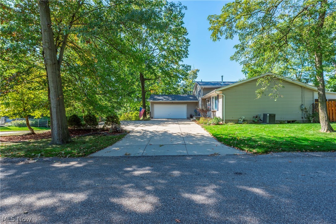75 Houghton Road Northfield, OH 44067 - Photo 47 of 48 Property exterior featuring a concrete driveway, attached garage, and mature trees
