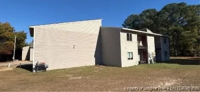 a view of a house with backyard and trees