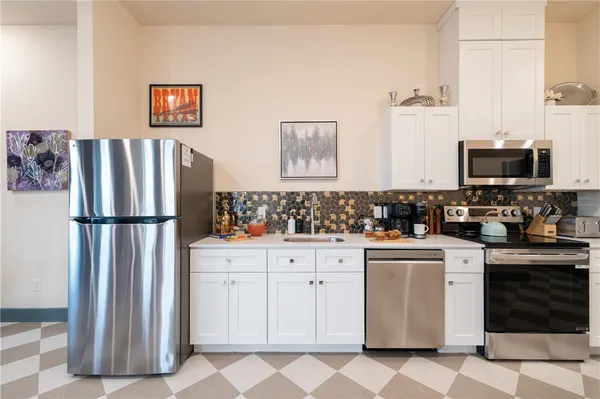 a kitchen with white cabinets and stainless steel appliances