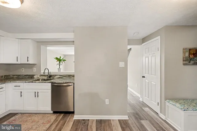 a kitchen with granite countertop a sink and wooden floor