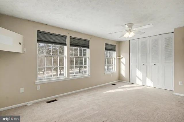 an empty room with a empty space and a ceiling fan