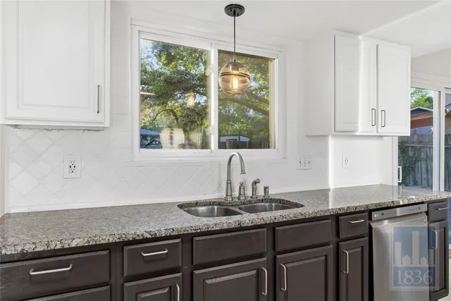 a kitchen with granite countertop a sink and a window
