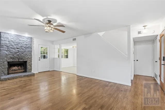 a view of empty room with wooden floor and fireplace