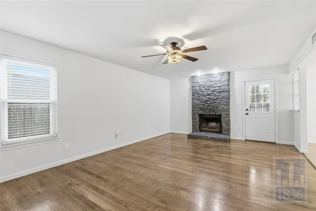 a view of empty room with a fireplace and a window