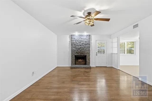 a view of an empty room with a window and fireplace