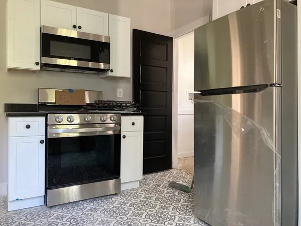 a kitchen with stainless steel appliances granite countertop a refrigerator stove and microwave