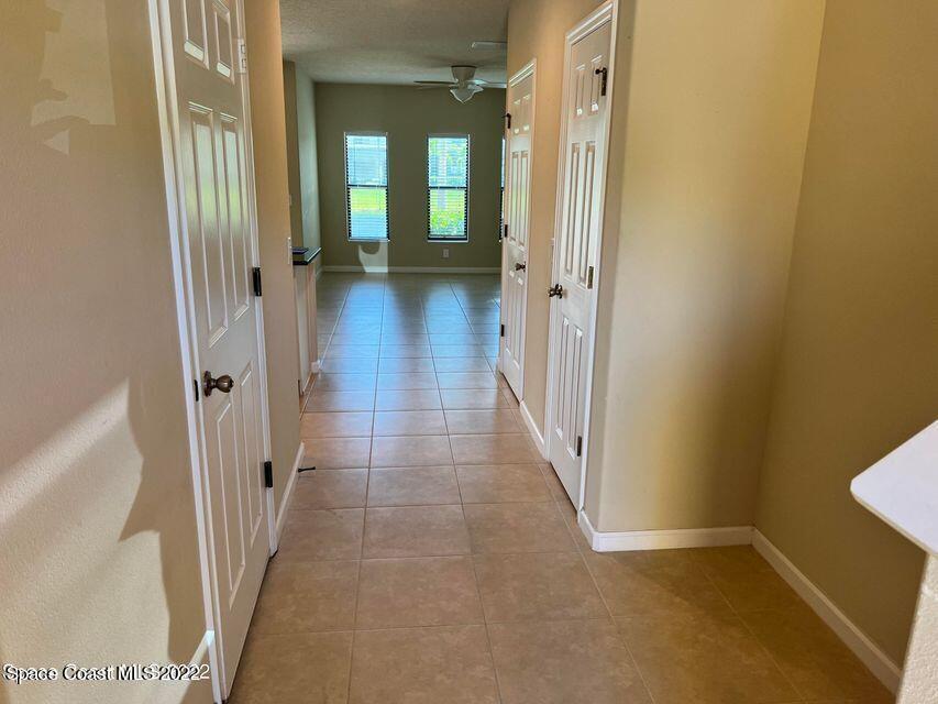 1420 Lara Circle, Unit 105 Rockledge, FL 32955 - Photo 2 of 20 a view of a hallway with wooden floor and a bathroom