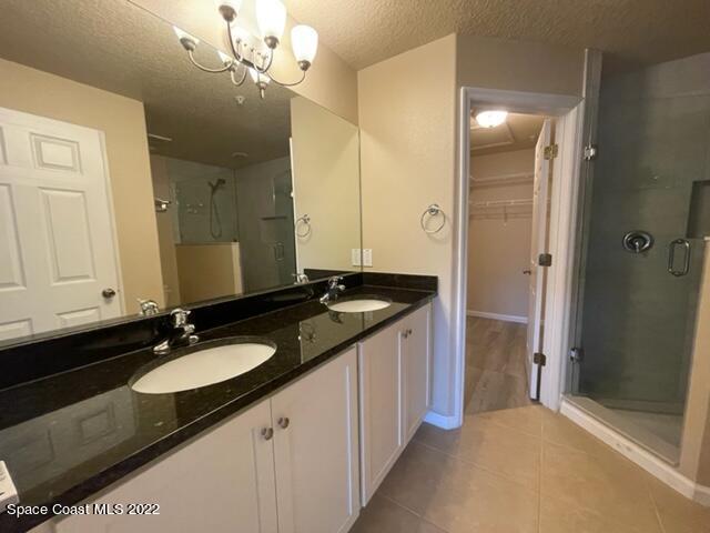 1420 Lara Circle, Unit 105 Rockledge, FL 32955 - Photo 8 of 20 a bathroom with a granite countertop sink a large mirror and a shower