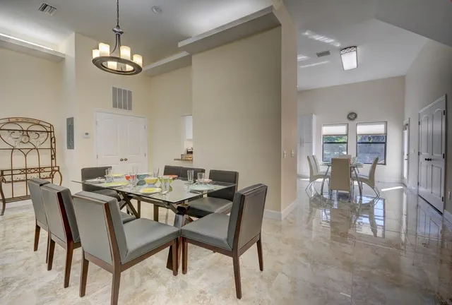 a view of a dining room with furniture and chandelier