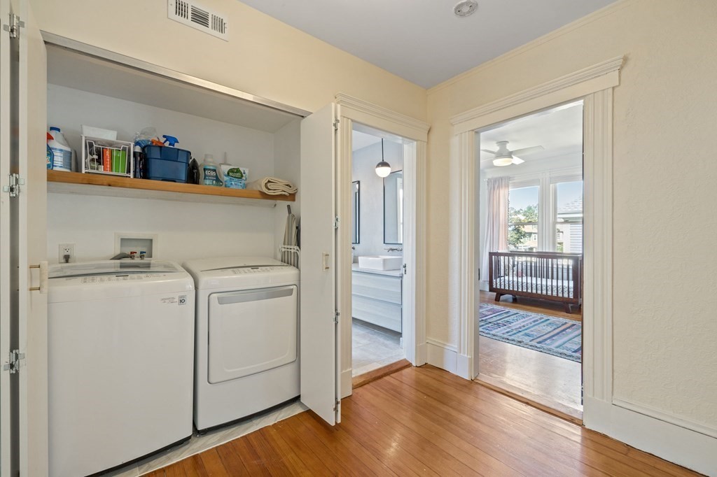 18 Alpha Road Boston, MA 02124 - Photo 18 of 42 a view of washer and dryer with kitchen in the background