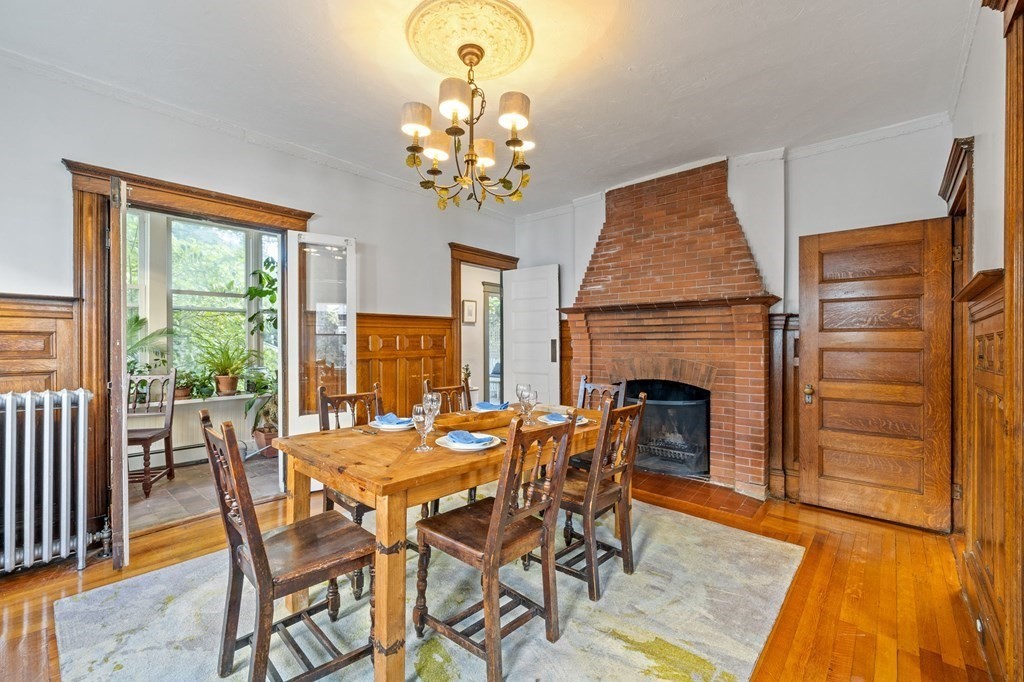 18 Alpha Road Boston, MA 02124 - Photo 6 of 42 a dining room with furniture a chandelier and wooden floor