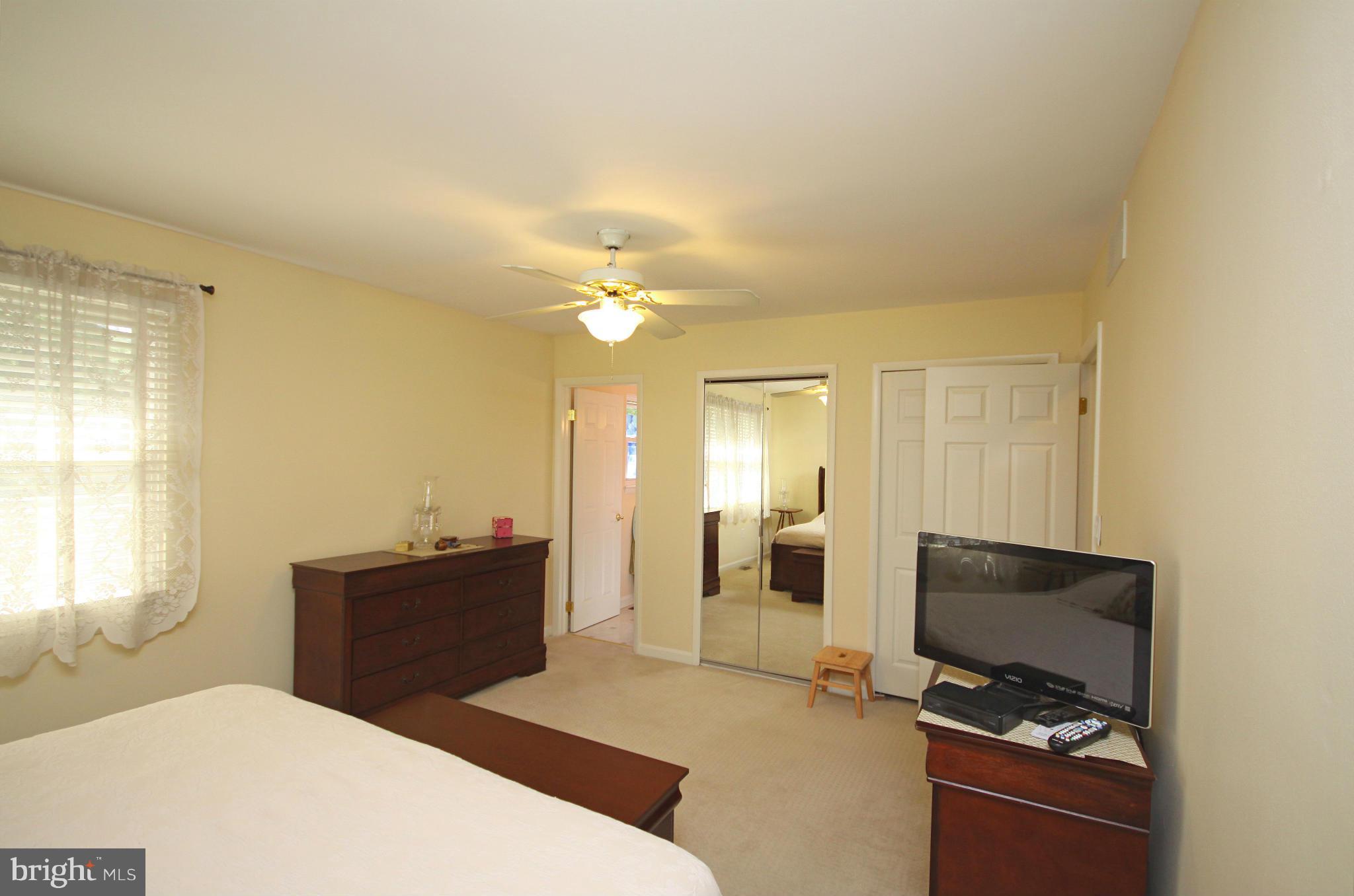 7707 Mahogany Road Severn, MD 21144 - Photo 14 of 30 a bedroom with a bed and a chandelier