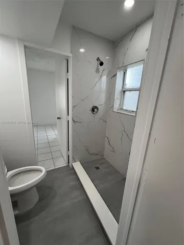 a bathroom with a glass door shower and toilet