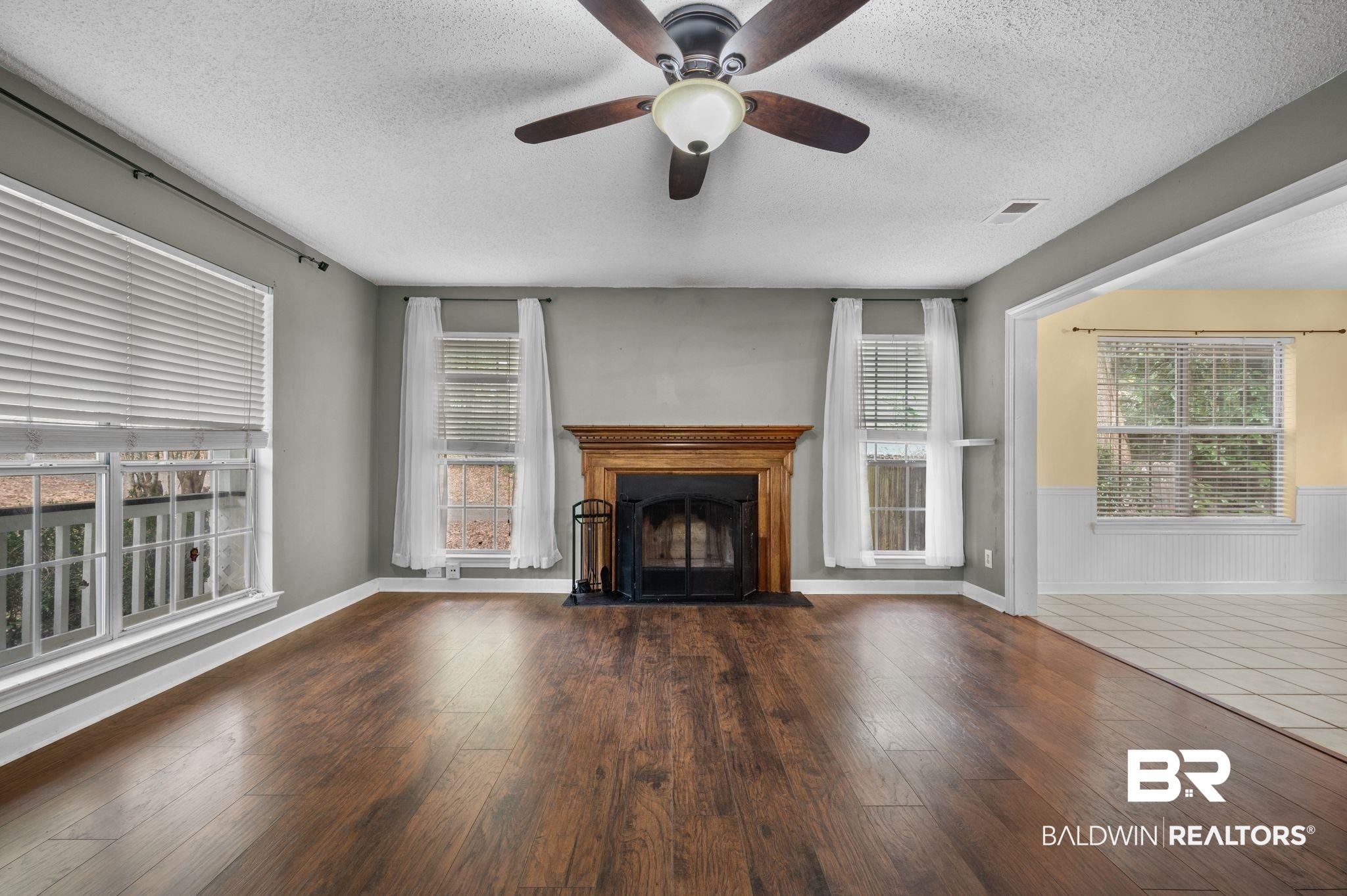 100 Montclair Loop Daphne, AL 36526 - Photo 28 of 39 Unfurnished living room featuring dark hardwood / wood-style floors, a textured ceiling, and plenty of natural light