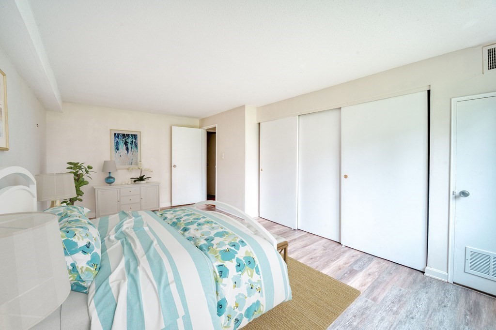 3 Post Oak Lane, Unit 4 Natick, MA 01760 - Photo 14 of 34 a bedroom with a large bed and a chandelier