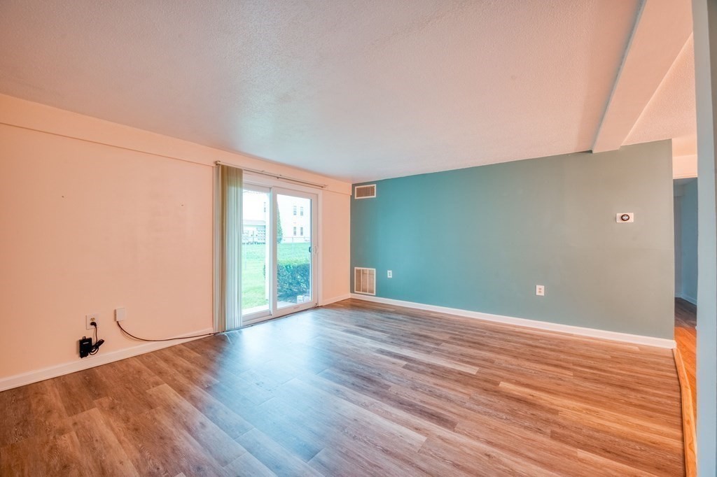 3 Post Oak Lane, Unit 4 Natick, MA 01760 - Photo 5 of 34 a view of an empty room with wooden floor and a window