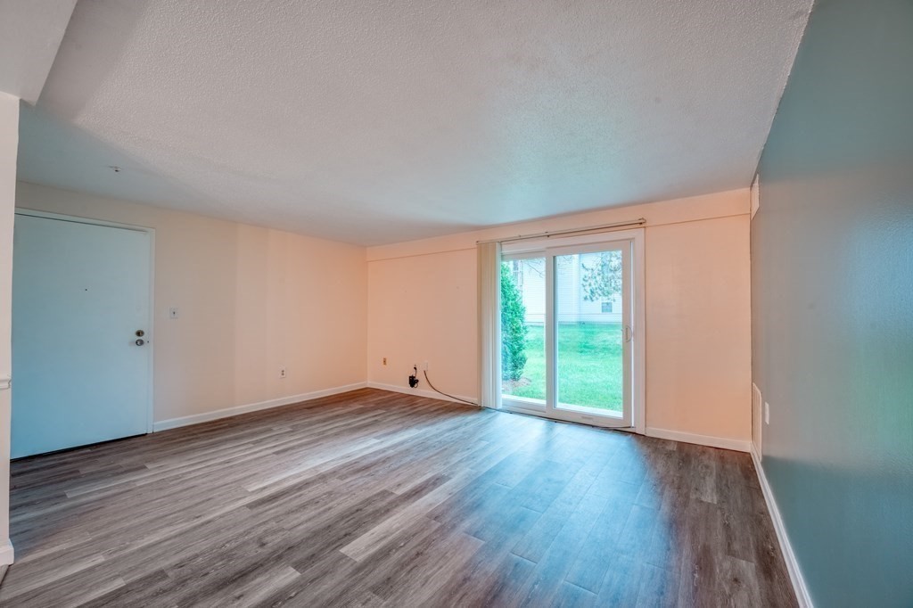 3 Post Oak Lane, Unit 4 Natick, MA 01760 - Photo 6 of 34 a view of an empty room with wooden floor and a window