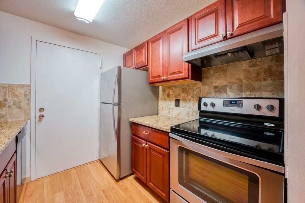 3 Post Oak Lane, Unit 4 Natick, MA 01760 - Photo 10 of 34 a kitchen with wooden cabinets and a stove top oven