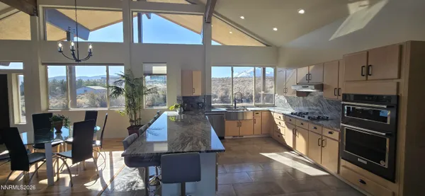 a large kitchen with stainless steel appliances kitchen island granite countertop a refrigerator and cabinets