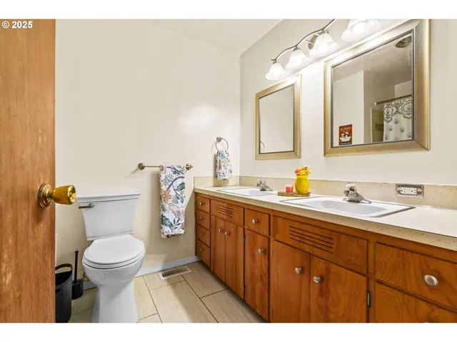 a bathroom with a granite countertop toilet sink and mirror
